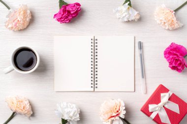Anneler Günü 'nün dizayn birleşimi karanfil çiçeği, bayram hediyesi fikri ve annemin masa arkasında defter günlüğü..