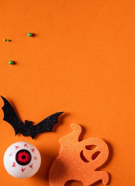 Turuncu kağıt masa zemininde yaratıcı Cadılar Bayramı konsepti dekorasyonunun en üst görüntüsü.