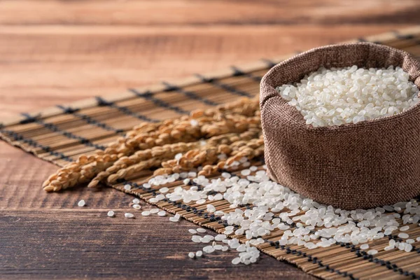 Çiğ beyaz cilalanmış yenilebilir pirinç ahşap masa arkasında, organik tasarım konsepti..