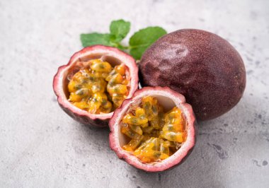 Gri masa arkaplanındaki lezzetli taze tutku meyvesini kapat..