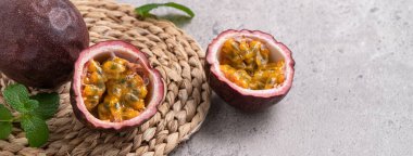 Gri masa arkaplanındaki lezzetli taze tutku meyvesini kapat..