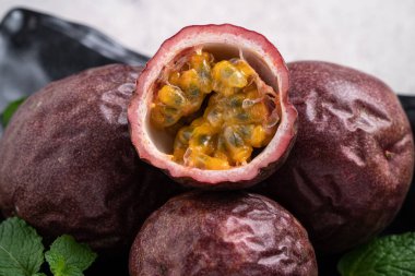 Gri masa arkaplanındaki lezzetli taze tutku meyvesini kapat..