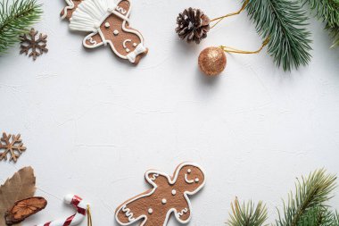 Süslü Noel kurabiyelerinin beyaz masa arkaplanında fotokopi alanı ve bayram kutlaması konseptiyle üst görünümü.