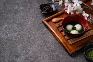 Matcha Big Tangyuan 'ı (tang yuan) ahşap masa arkasında tatlı bir kibrit çorbası ile festival yemeği için kapatın..
