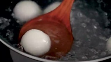 Kış Gündönümü ve Yuanao Festivali için geleneksel büyük lezzetli tangyuan, tang yuan, pirinç köftesi pişirme ve kaynama.