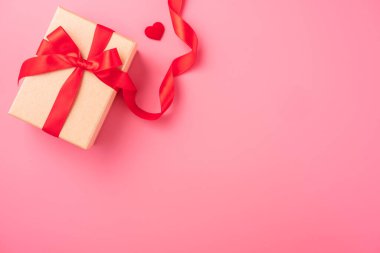 Kraft hediye kutusu içinde güzel kırmızı kurdele ve gül, Sevgililer Günü konsepti, yıldönümü, anneler günü ve doğum günü selamı, fotokopi alanı, üst manzara.