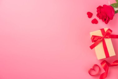Kraft hediye kutusu içinde güzel kırmızı kurdele ve gül, Sevgililer Günü konsepti, yıldönümü, anneler günü ve doğum günü selamı, fotokopi alanı, üst manzara.