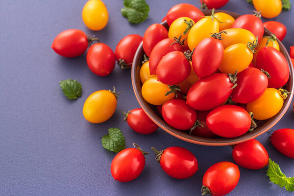 Свежие помидоры черри в деревянной чаше изолированы на голубом фоне, закрываются, копируют пространство