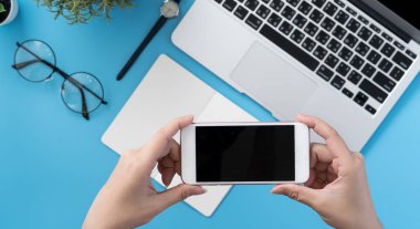 Ofis masası kavramını moda aksesuarlarına bağlayan sosyal ağ, akıllı telefon tutan bir kadınla minimum iç mekan, üst görünüm, düz mekan, taklit alanı
