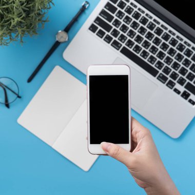 Ofis masası kavramını moda aksesuarlarına bağlayan sosyal ağ, akıllı telefon tutan bir kadınla minimum iç mekan, üst görünüm, düz mekan, taklit alanı
