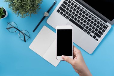 Ofis masası kavramını moda aksesuarlarına bağlayan sosyal ağ, akıllı telefon tutan bir kadınla minimum iç mekan, üst görünüm, düz mekan, taklit alanı