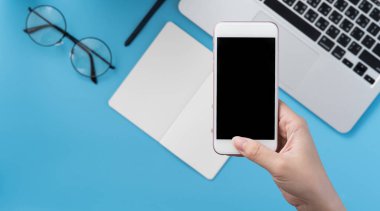Ofis masası kavramını moda aksesuarlarına bağlayan sosyal ağ, akıllı telefon tutan bir kadınla minimum iç mekan, üst görünüm, düz mekan, taklit alanı