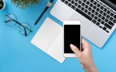 Ofis masası kavramını moda aksesuarlarına bağlayan sosyal ağ, akıllı telefon tutan bir kadınla minimum iç mekan, üst görünüm, düz mekan, taklit alanı