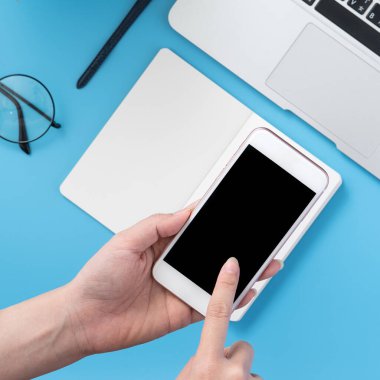 Ofis masası kavramını moda aksesuarlarına bağlayan sosyal ağ, akıllı telefon tutan bir kadınla minimum iç mekan, üst görünüm, düz mekan, taklit alanı