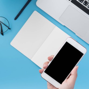 Ofis masası kavramını moda aksesuarlarına bağlayan sosyal ağ, akıllı telefon tutan bir kadınla minimum iç mekan, üst görünüm, düz mekan, taklit alanı