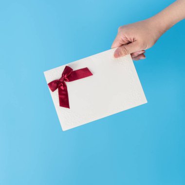 Genç bir kadın bir hediye kartı veriyor. İçinde tebrik kartı, bayram konsepti var. Sürpriz, fotokopi alanı, üst manzara festivali kutluyor.