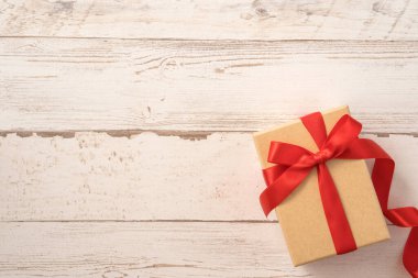 Kraft hediye kutusu, kırmızı kurdele, hediye konsepti ve sevgililer günü, yıldönümü, anneler günü ve doğum günü sürprizi, düz konum, üst manzara