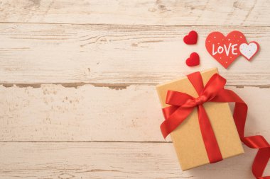 Kraft hediye kutusu, kırmızı kurdele, hediye konsepti ve sevgililer günü, yıldönümü, anneler günü ve doğum günü sürprizi, düz konum, üst manzara