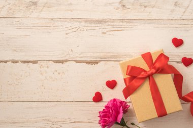 Kırmızı kurdele ve karanfilli Kraft hediye kutusu. Anneler gününde hediye verme konsepti. Sürpriz, düz yatak, üst manzara.