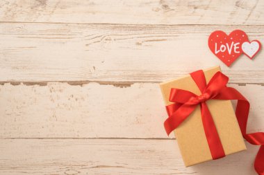 Kraft hediye kutusu, kırmızı kurdele, hediye konsepti ve sevgililer günü, yıldönümü, anneler günü ve doğum günü sürprizi, düz konum, üst manzara