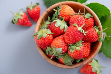 Bir kase güzel ve lezzetli çilek mavi arka planda izole edilmiş, yakın plan, üst görünüm, telif alanı.