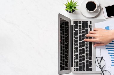 Bir kadın çevrimiçi ödeme ya da alışveriş yapıyor, ofis masasında kredi kartı ve cep telefonu taklidi yapıyor güzel moda mermer arka plan, üst görünüm, düz alan, telif alanı.