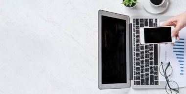 Bir kadın çevrimiçi ödeme ya da alışveriş yapıyor, ofis masasında kredi kartı ve cep telefonu taklidi yapıyor güzel moda mermer arka plan, üst görünüm, düz alan, telif alanı.