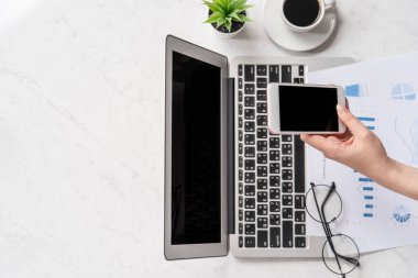 Bir kadın çevrimiçi ödeme ya da alışveriş yapıyor, ofis masasında kredi kartı ve cep telefonu taklidi yapıyor güzel moda mermer arka plan, üst görünüm, düz alan, telif alanı.