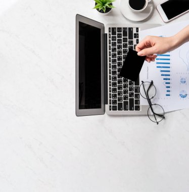 Bir kadının internet üzerinden alışveriş yapması, ofis masasında kart ve cep telefonunu taklit etmesi, güzel moda mermer arka planda izole edilmesi, fotokopi alanı, üst manzara, düz alan, yakın çekim