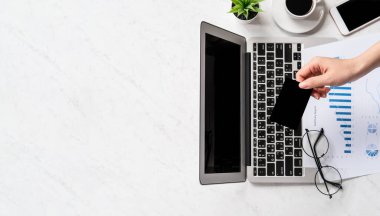 Bir kadının internet üzerinden alışveriş yapması, ofis masasında kart ve cep telefonunu taklit etmesi, güzel moda mermer arka planda izole edilmesi, fotokopi alanı, üst manzara, düz alan, yakın çekim