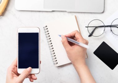 Bir kadının konsepti muhasebe yapmaktır, ofis masasında kart ve cep telefonunu taklit etmektir güzel moda mermer arka plan, kopya alanı, üst görünüm, düz alan, yakın çekim