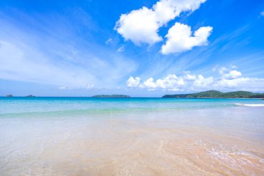 Güneşli mavi gökyüzü ile izole edilmiş yumuşak dalgaları olan harika, altın renkli kumlu plaj. Tropikal sakin turizm fikri, kopyala alanı, kapat