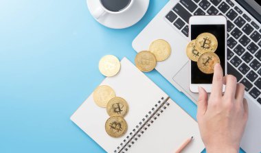 Bir kadın temiz mavi ofis çalışma masasına izole edilmiş para kavramını hesaplıyor bitcoin ve kahve fincanı, çalışma alanı tasarımı, modelleme, üst görünüm, düz görünüm, kopyalama alanı, kapatma