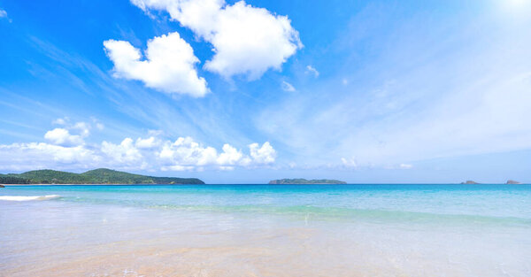 Beautiful amazing gold colored sandy beach with soft waves isolated with sunny blue sky. Concept of tropical calm tourism idea, copy space, close up
