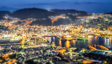 Business concept, tilt shift effect modern cityscape of nagasaki dusk from mount inasa, the new top 3 nightview of the world, aerial view, copy space clipart