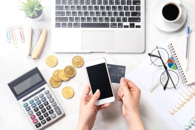 Modern bir mermer ofis masasına izole edilmiş bir telefon ve kartla online ödeme yapan bir kadın konsepti, üst görünüm, fotokopi alanı, düz yatak, yaşam tarzı, kapatın.