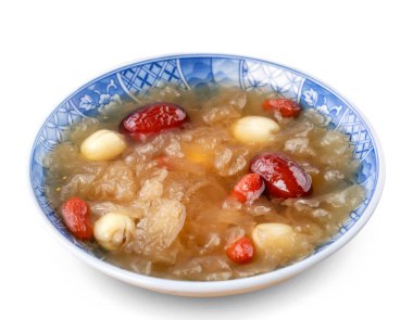 Close up of traditional Chinese sweet snow white fungus soup with lotus seed, red dates (jujube) and wolfberry (goji, gojiberry) isolated on white background.