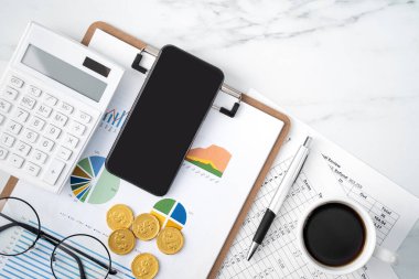 Akıllı telefon, rapor ve mermer beyaz masa arka planı ofis arzı ile yıllık özet inceleme kavramının en üst görünümü.