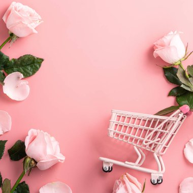 Sevgililer Günü alışveriş tasarımı konsepti pembe gül çiçeği ve el arabası arka planda.