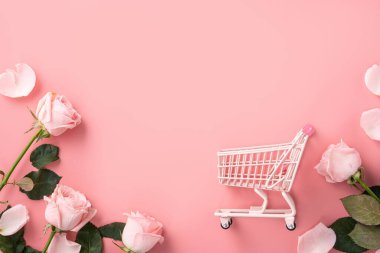 Sevgililer Günü alışveriş tasarımı konsepti pembe gül çiçeği ve el arabası arka planda.