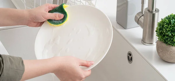 가정주부를 가까이 함으로써 부엌에서 스폰지 설거지를 함으로써 설거지를 — 스톡 사진