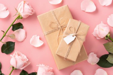 Sevgililer Günü tasarım konsepti pembe gül çiçeği ve paketlenmiş Kraft hediye kutusu ve pembe masa arkaplanı.