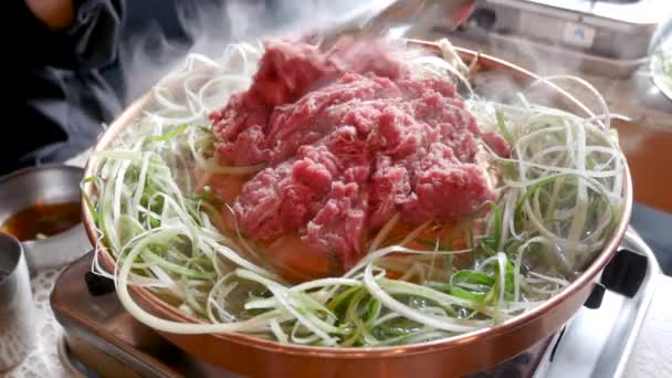 韓国料理店での黒豚料理 ネギ入り鉄板の上での新鮮なおいしい韓国料理の終わり — ストック動画