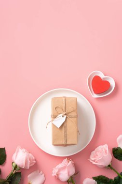Sevgililer Günü hediyesinin ve yemek tasarımı konseptinin en üst görüntüsü pembe masa arkaplanlı pembe gül çiçeğiyle