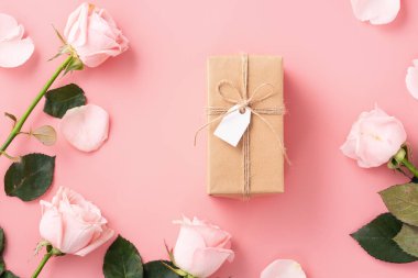 Sevgililer Günü tasarım konsepti pembe gül çiçeği ve paketlenmiş Kraft hediye kutusu ve pembe masa arkaplanı.