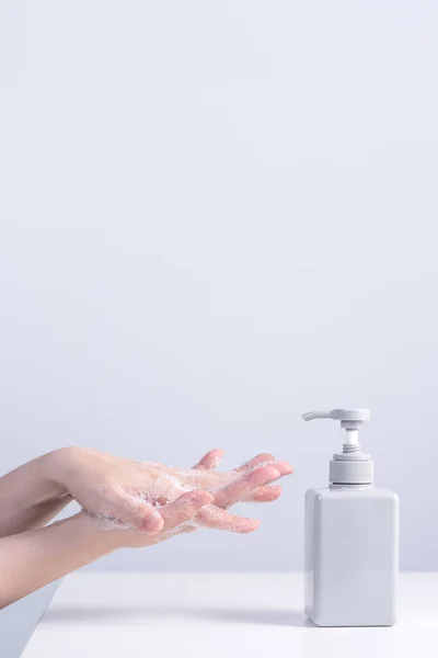 Washing hands by using liquid soap, concept of hygiene to protective pandemic coronavirus isolated on gray white background, close up.