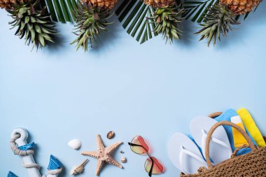 Yaz meyvesi tasarımı konsepti. Deniz kabukları, şapka, ananas ve mavi arka planda palmiye yapraklarıyla tatil gezilerinin en üst manzarası..