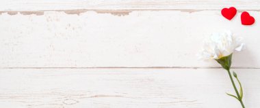 Anneler günü konsept fotoğrafçılığı - güzel karanfiller ve kalpler parlak ahşap bir masaya izole edilmiş beyaz bir kart, kopyalama alanı, düzlük, üst manzara, taklit