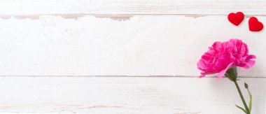 Anneler günü konsept fotoğrafçılığı - güzel karanfiller ve kalpler parlak ahşap bir masaya izole edilmiş beyaz bir kart, kopyalama alanı, düzlük, üst manzara, taklit