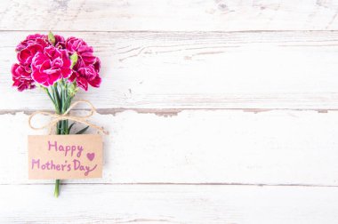 Anneler günü konsept fotoğrafçılığı - parlak ahşap bir masa üzerinde izole güzel karanfiller, kopyalama alanı, düz yatış, üst manzara, maket